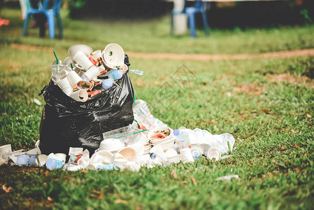 泡沫箱食品残渣和塑料瓶溢出黑垃圾袋外图片