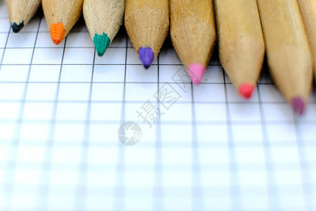 用于绘图的笔记本格子纸上的一组彩色铅笔的特写回到学校的概念复制空间图片