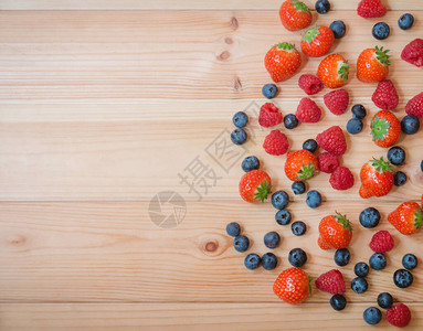 草莓蓝莓和草莓作为木质背景的边框顶层视背景图片