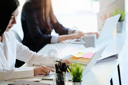 商业团队使用膝上型计算机在现代办公室工作场所进行营销规划单图片