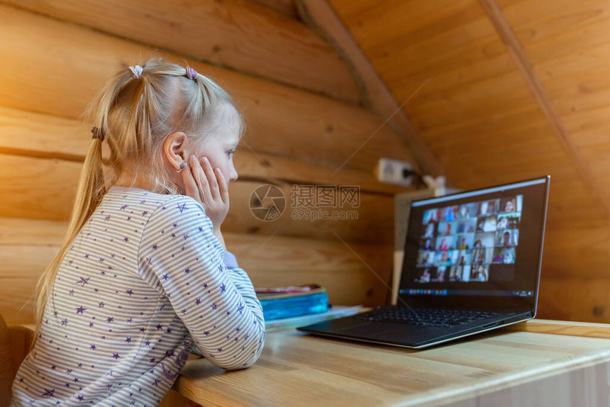 可爱的caucasian小金发女孩坐在书桌和笔记本电脑一起与教师和班级在线视频聊天学校课时远程教育概念隔离图片