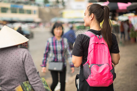 一位女背包客在户外街头购物购物探索图片