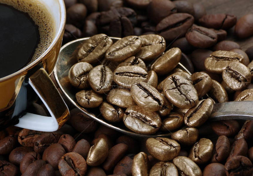 金咖啡豆和一杯咖啡奢华的概念非同寻常勺子里的咖啡豆咖图片
