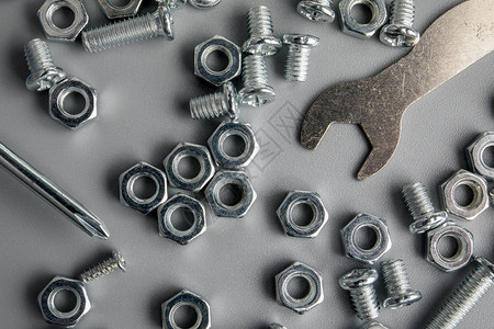 灰色背景中的金属螺栓和螺母镀铬螺栓和螺母一图片