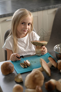 女孩切蘑菇成碎片她这样做很小心女孩用刀有实心蘑菇图片
