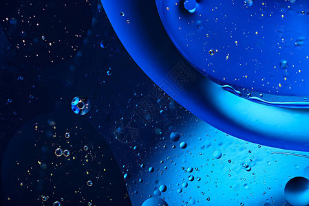 典型蓝色背景水面的抽象石油泡沫图片