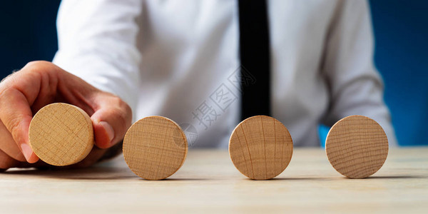 商人在桌子上排成一排把四个空白的木环放图片