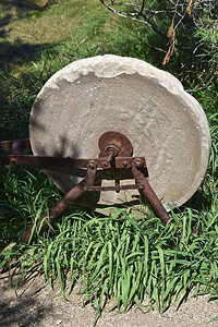 一个老旧的磨轮用来在长草丛图片
