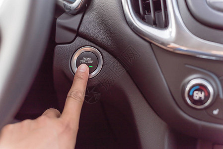 自动启停关闭现代汽车上按下启动停止发动机按钮的手指亚洲手指启背景