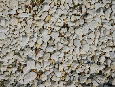 背景样本产品近身墙状灰色石块和小白石块环绕在花园图片