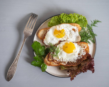炸面包三明治配炒鸡蛋和新鲜生菜用于圆图片