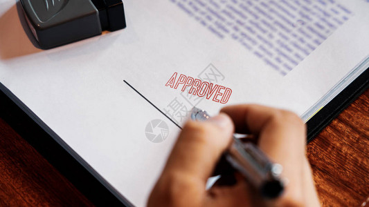 高级商人男手在贷款文件协议律师手概念上批准印章后在证书合同图片
