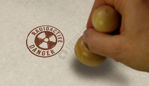 放射危险符号邮票和冲压手原子能警报辐射警报和背景图片