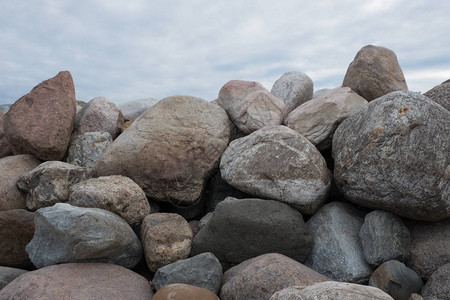 挡土墙由石头巨石制成火山岩花岗岩玄武岩辉长岩的石头海滩上的银行保护保护海岸免受海浪的破背景图片