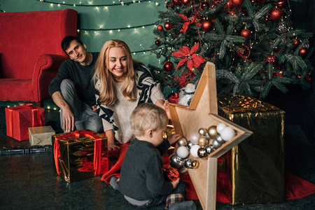 家庭肖像爸妈和一个小孩在圣诞节主题图片