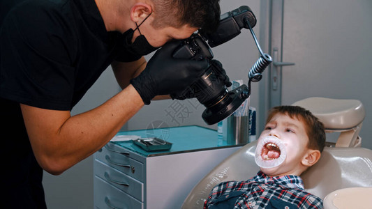 一个在牙科接受治疗的男孩张开嘴巴图片