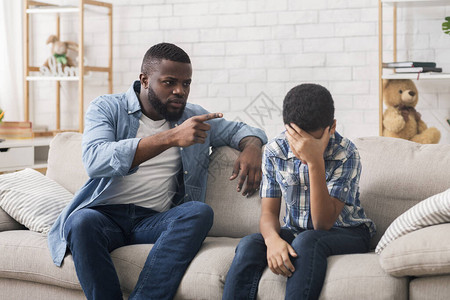 愤怒的黑人父亲责骂顽固的小儿子图片