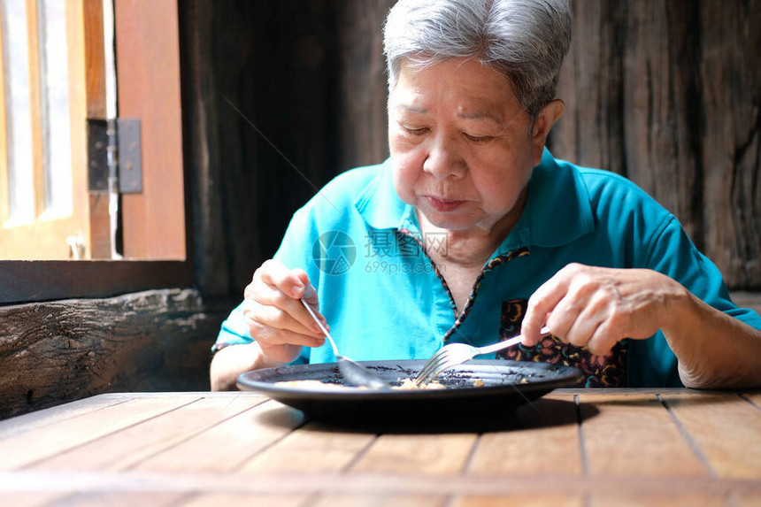 老年亚洲老年妇女在餐厅吃饭成熟的图片