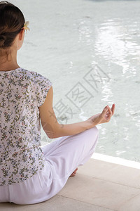 女人在泳池的莲花瑜伽姿势中图片