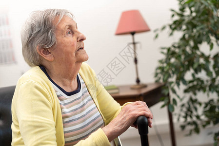 一位年长妇女坐在拐杖上背景图片