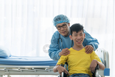 照顾和帮助残疾男孩康复的亚洲志愿医生留在医院图片