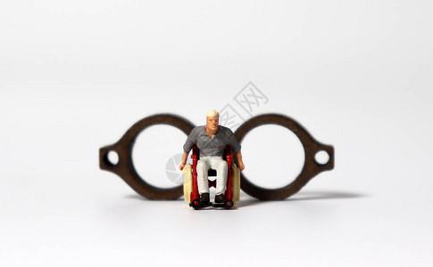 一个坐在轮椅上站在木制迷你眼镜背景图片