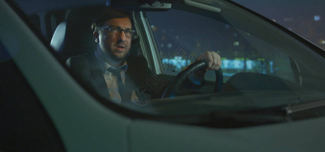 中度男子在夜间开车时打电话背景图片