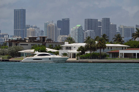 白色马达游艇在迈阿密海滩RivoAlto岛的豪华地产上巡游图片