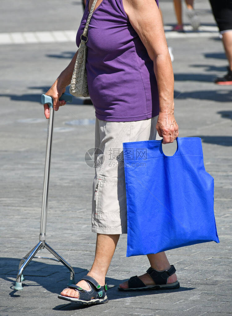 老妇人带着助行器走在街上图片