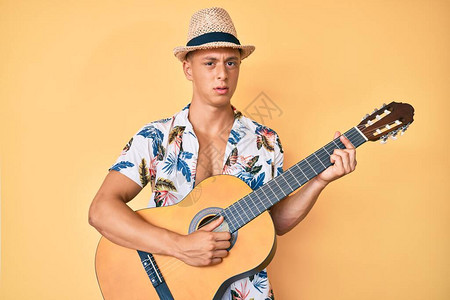 穿着暑假风格的黑人男孩弹着古典吉他毫无头绪和困惑的表情图片