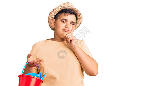 玩夏铲和水桶玩具的小男孩严肃的脸用手托着下巴思考问题图片