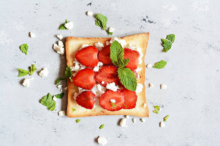 早餐用水果草莓薄荷和白软干酪烤面包图片