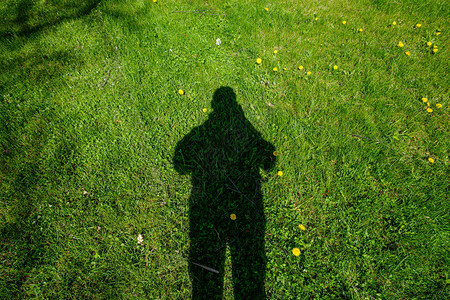 夏日绿色草地上的黑色大人影图片