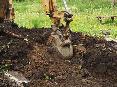 挖土机在地上挖一个洞图片