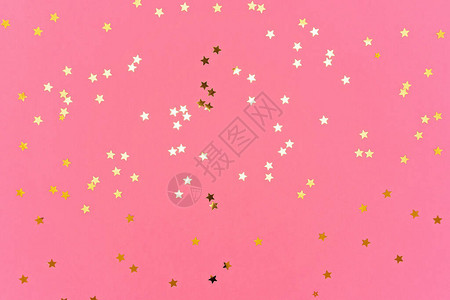 金色星的照片在粉红色的时尚背景上闪发光您的项目的节日背景庆祝概念图片