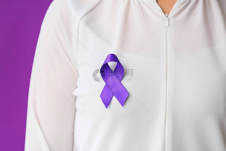 以紫色丝带作为世界癌症日标志的女子在彩图片