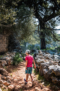 小男孩在希腊克里特岛老村庄的泥土路上走过图片