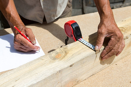 木匠检查材料的质量并计算生产所需的数量用天然树制造家具员工使图片