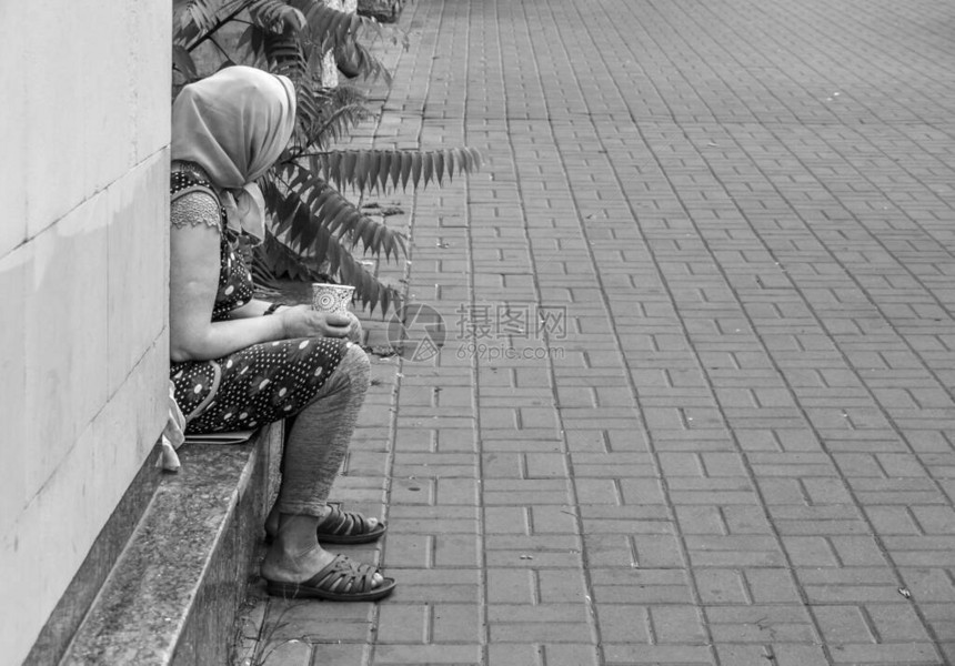 街上的乞丐女人靠墙坐着图片