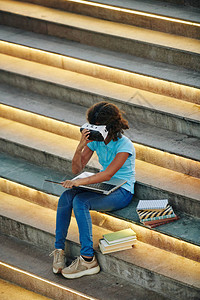 使用VR头盔笔记本电脑和书籍对无法识别的女学生进行垂直高角度垂直拍摄图片