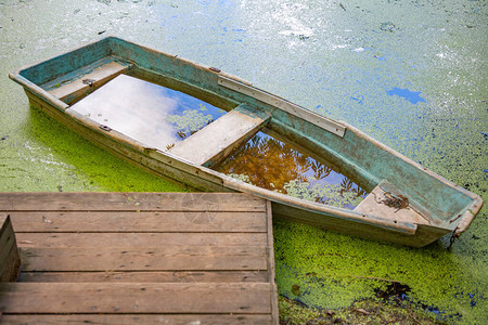 白天浮萍池附近废弃的旧铁船背景图片