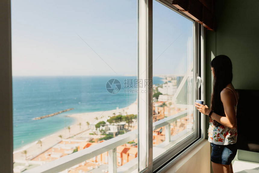 年轻妇女在她公寓窗户前图片