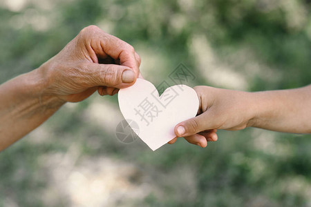 孩子的手和老手祖母握着心爱家保护儿童老人祖母友图片