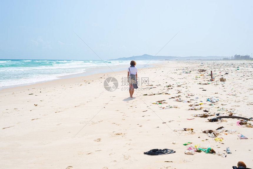 女人独自走在热带海滩上图片