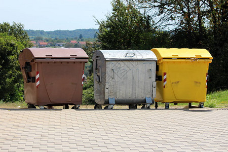 三种用于生态分类垃圾的大型金属和塑料垃圾容器图片