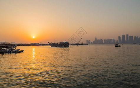 被称为Dhows的传统船停泊在卡塔尔多哈伊斯兰博物馆附近的港口图片