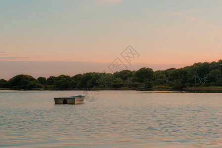 一艘孤单的船在玛莎葡萄园夕阳下在盐池图片