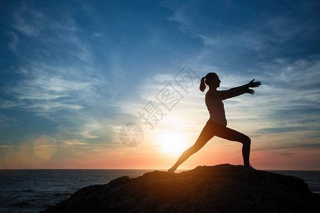 瑜伽女孩在日落时在海边做健身图片