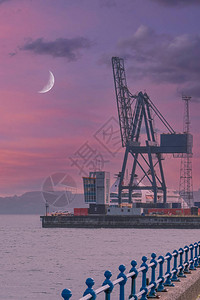格林诺克苏格兰海洋码头的大起重机和吉卜机以及港口一侧的大型班轮或巡洋舰背景图片