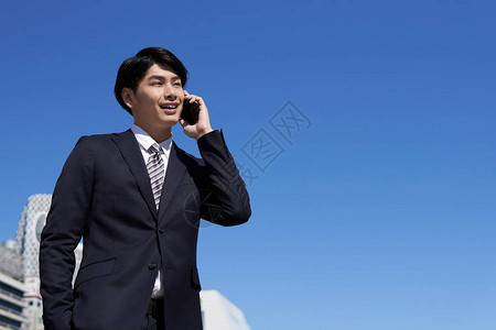 日本男商人用智能手机打电话图片